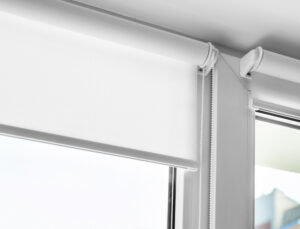 Detail shot of white roller shades on a window